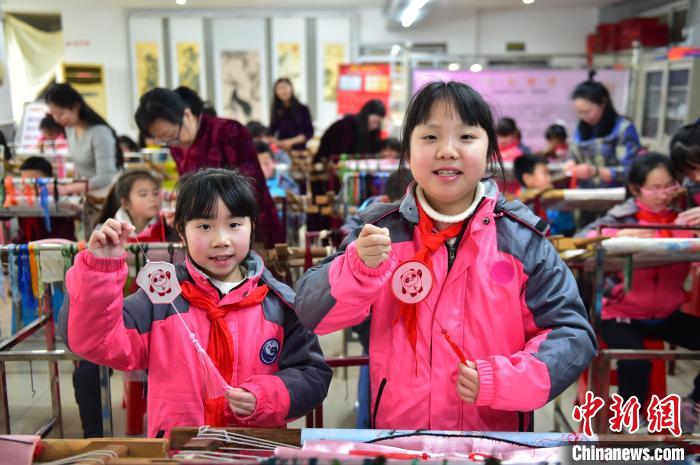 圖為小學(xué)生展示繡制好的2022年北京冬奧會(huì)吉祥物“冰墩墩”形象?！∮髟屏?攝