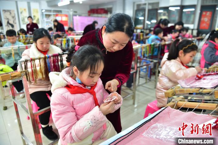 江西省級(jí)非遺豫章繡傳承人手把手指導(dǎo)小學(xué)生繡制2022年北京冬奧會(huì)吉祥物“冰墩墩”形象?！∮髟屏?攝