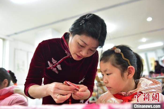 江西省級(jí)非遺豫章繡傳承人手把手指導(dǎo)小學(xué)生繡制2022年北京冬奧會(huì)吉祥物“冰墩墩”形象?！∮髟屏?攝