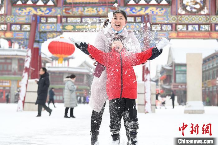 2月13日，家長與小朋友在呼和浩特市大召廣場(chǎng)享雪趣。　劉文華 攝
