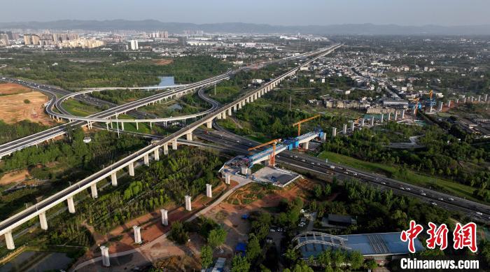 航拍正在建設(shè)的跨越成都繞城高速公路連續(xù)梁施工現(xiàn)場，旁邊依次為已運營的成渝高速鐵路和機場高速公路?！⒅铱?攝