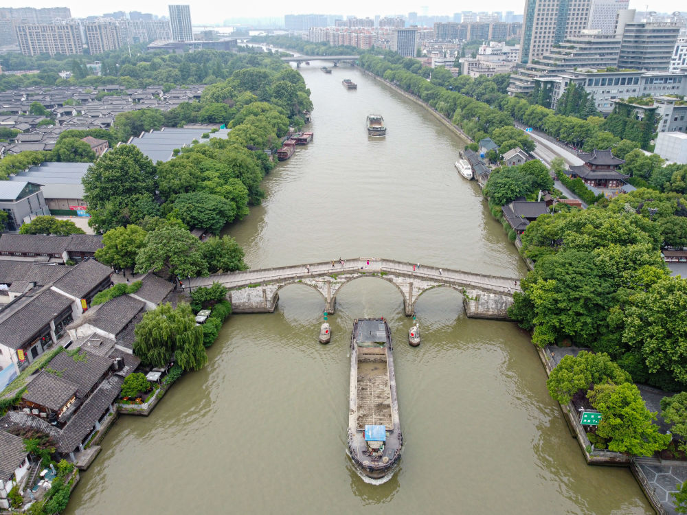 5月27日，一艘貨船駛過京杭大運河南端標志建筑杭州拱宸橋。(無人機照片)新華社記者江漢 攝