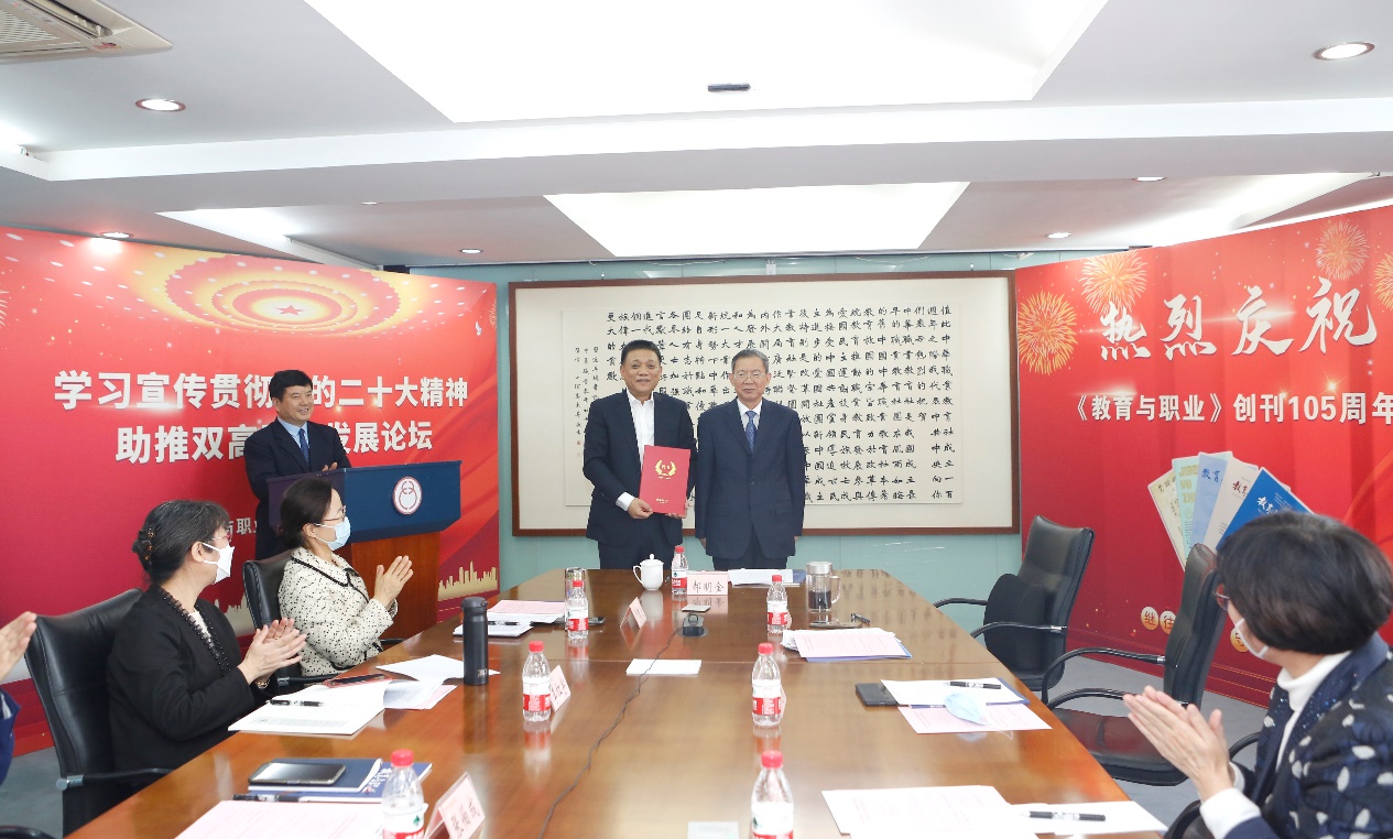 郝明金為《教育與職業(yè)》雜志編委代表陳曉明頒發(fā)聘書。中華職教社供圖
