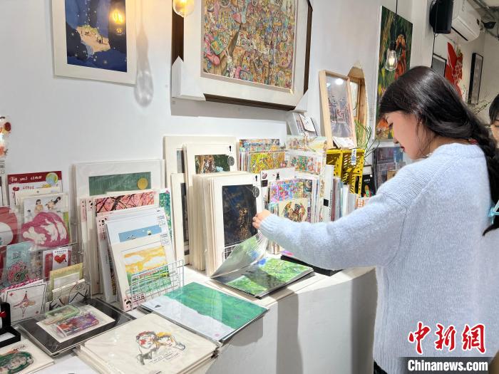 圖為藝術品商店內，顧客挑選插畫作品。　鐘旖 攝