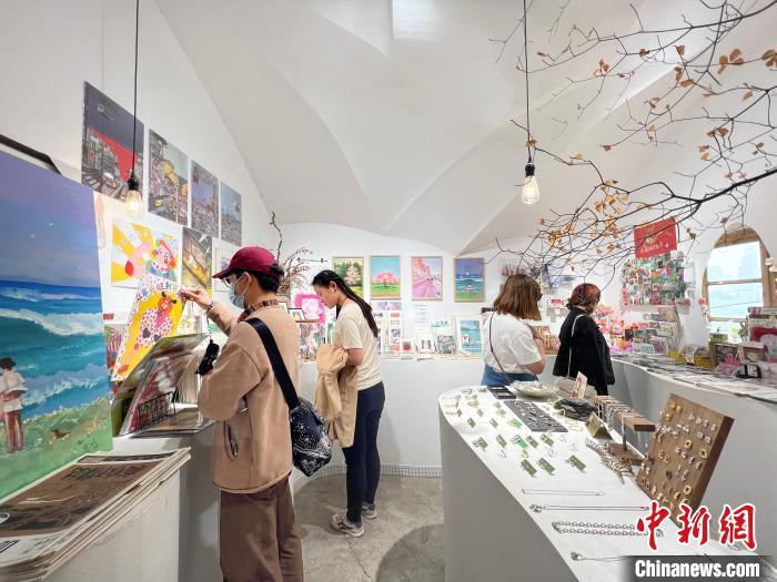 圖為藝術品商店內，顧客挑選插畫作品?！＄婌?攝