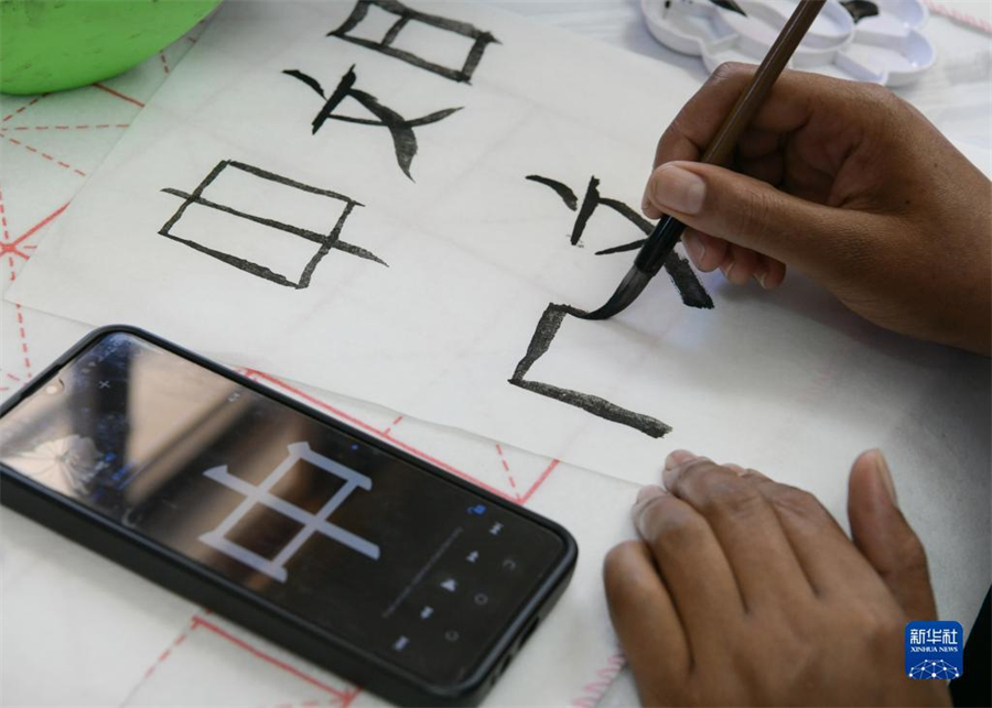 4月18日，肯尼亞學(xué)生在內(nèi)羅畢大學(xué)孔子學(xué)院舉辦的活動(dòng)上寫毛筆字?？夏醽唭?nèi)羅畢大學(xué)孔子學(xué)院18日舉辦“中文，增進(jìn)文明對(duì)話”主題活動(dòng)，慶祝即將到來的第14個(gè)聯(lián)合國中文日?？夏醽唽W(xué)生參與互動(dòng)，進(jìn)行書法、剪紙、唱中文歌等活動(dòng)。新華社記者 韓旭 攝