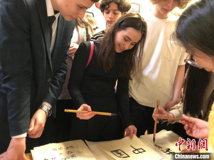4月21日，莫斯科國立語言大學(xué)孔子學(xué)院附屬中學(xué)舉辦“國際中文日”活動(dòng)，學(xué)生們學(xué)寫漢字?！∧箍茋⒄Z言大學(xué)孔子學(xué)院 供圖