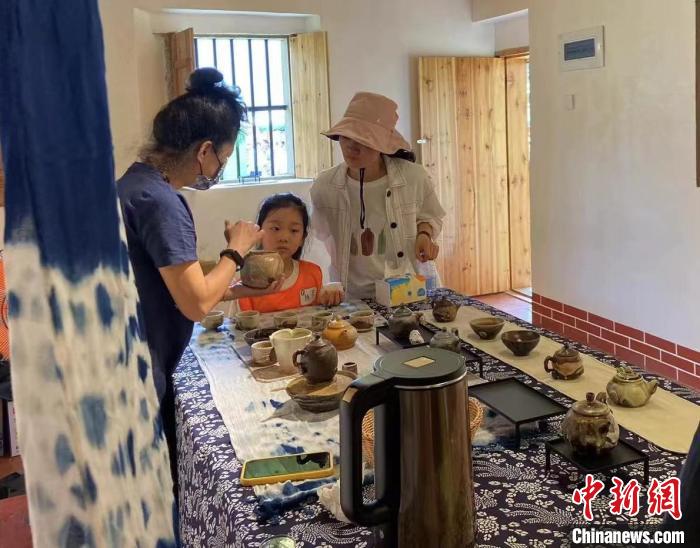 圖為：游客正在咨詢臺灣柴燒作品?！∪~秋云 攝
