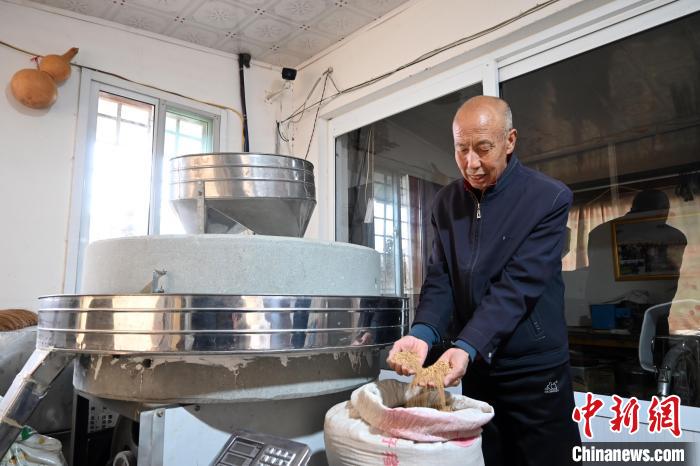 李家莊村民谷文朝重拾父輩的手藝，做起石磨面粉的營生?！〉杂鸺?攝