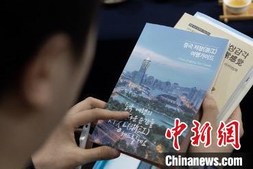 參展觀眾閱讀浙江文旅手冊?！《≌裾?攝