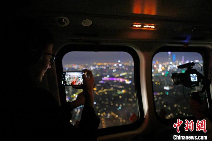 6月3日晚，游客乘坐上海新空直升機(jī)有限公司直升機(jī)開啟鳥瞰黃浦江空中圓夢之旅，并用手機(jī)拍攝城市夜景?！∫罅⑶?攝