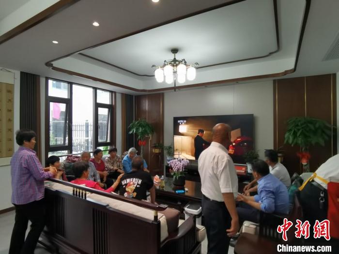 親友們集中在費(fèi)俊龍家中觀看返程的視頻。　鐘升 攝