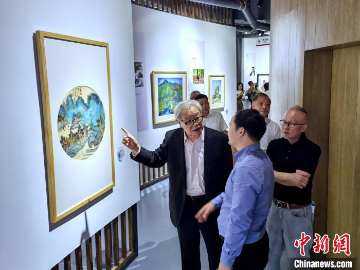 海峽兩岸藝術(shù)家畫展上，藝術(shù)家進(jìn)行藝術(shù)交流?！「毒窜?攝