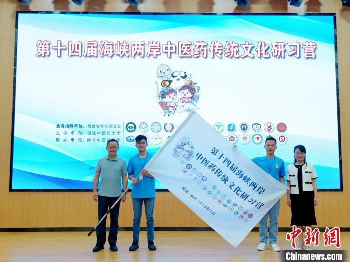 共青團(tuán)福建省委副書(shū)記吳雪(右一)、福建中醫(yī)藥大學(xué)黨委副書(shū)記林羽(左一)為兩岸學(xué)生代表頒授營(yíng)旗?！≡S燁婷 攝