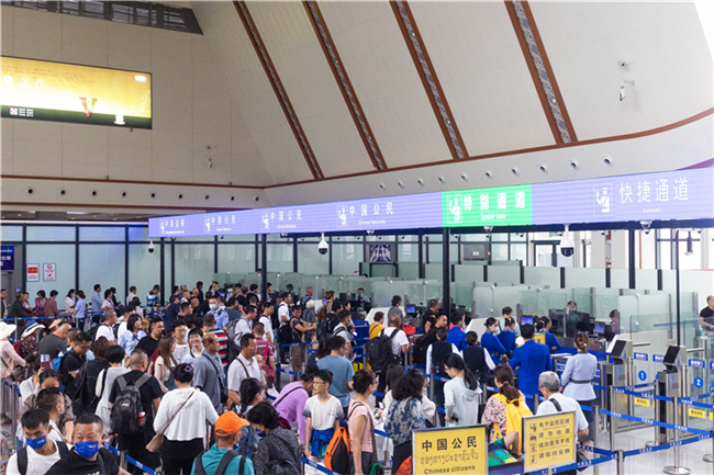 7月22日，乘坐中老鐵路國際旅客列車的旅客在磨憨邊檢大廳排隊候檢。衛(wèi)海林 攝