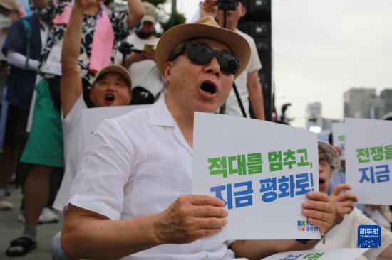 7月22日，在韓國首爾，人們手舉標語參與反戰(zhàn)游行。新華社發(fā)（楊暢 攝）