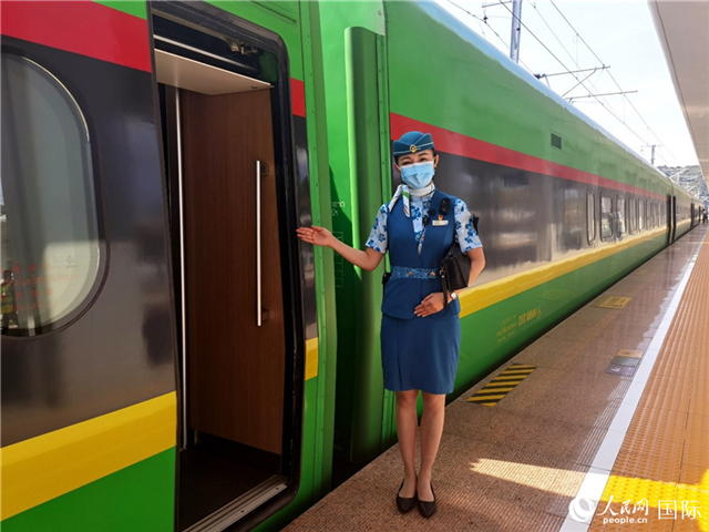 趙瑩靜站在“復(fù)興號”國際旅客列車車廂門口歡迎旅客上車。人民網(wǎng) 杜明明攝