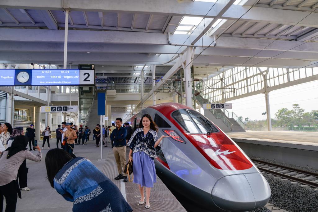10月17日，在印度尼西亞萬隆德卡魯爾站，乘客在站臺上和雅萬高鐵高速動車組列車合影。