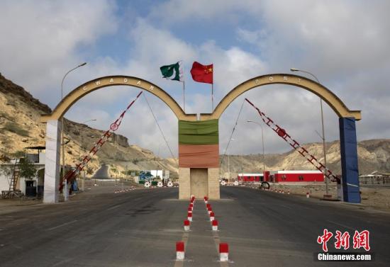 5月5日，瓜達(dá)爾港出入口的拱門。瓜達(dá)爾港是阿拉伯海沿岸的一座天然不凍良港，也是中巴經(jīng)濟(jì)走廊的南端起點(diǎn)。中國(guó)公司自2013年開(kāi)始取得瓜達(dá)爾港的運(yùn)營(yíng)權(quán)，目前各項(xiàng)工作逐步展開(kāi)。盡管自然條件差、物資匱乏，但瓜達(dá)爾卻有著重要的地理位置。瓜達(dá)爾是巴基斯坦通往波斯灣和阿拉伯海的大門，距離霍爾木茲海峽僅400公里。作為一帶一路有益補(bǔ)充的中巴經(jīng)濟(jì)走廊經(jīng)濟(jì)構(gòu)架的確立，使位于巴基斯坦最南端的瓜達(dá)爾港成為中巴經(jīng)濟(jì)走廊的一個(gè)重要出海口。<a target='_blank' href='/'><p  align=
