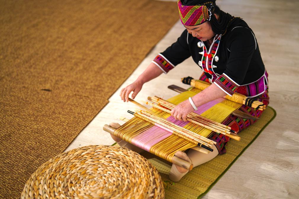 4月17日，黎族傳統(tǒng)紡染織繡技藝國(guó)家級(jí)代表性傳承人劉香蘭在2023年意大利米蘭設(shè)計(jì)周上展示黎錦織造技藝。新華社發(fā)
