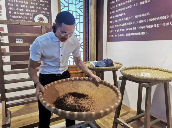 2023“一帶一路”媒體合作論壇聯(lián)合采訪團(tuán)團(tuán)員在非遺文化展示館體驗(yàn)中藥炮制技藝。（本報(bào)記者 黃超攝）