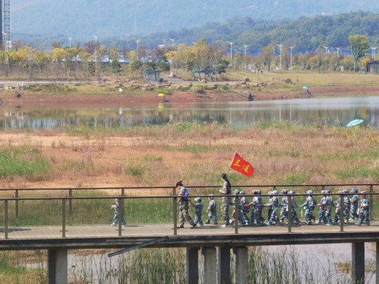 　　10月24日，秋游的幼兒園小朋友在老師帶領(lǐng)下走在清水塘公園里的木橋上。本報記者 常雯宜攝