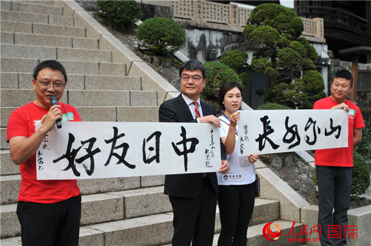 東京中國文化中心主任羅玉泉展示其為本次活動(dòng)書寫的題詞“中日友好，山高水長”。人民網(wǎng) 蔣曉辰攝