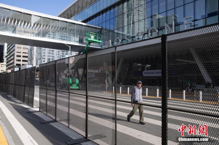 當(dāng)?shù)貢r(shí)間11月10日，一名行人從美國(guó)舊金山莫斯康中心周圍的金屬圍欄旁經(jīng)過。隨著亞太經(jīng)合組織(APEC)第三十次領(lǐng)導(dǎo)人非正式會(huì)議臨近，作為會(huì)議場(chǎng)地的莫斯康中心附近出現(xiàn)金屬圍欄，執(zhí)勤警察也大幅增加。<a target='_blank' href='/'><p  align=