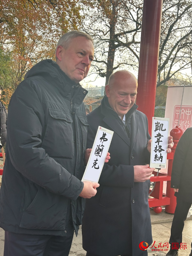 柏林市長(zhǎng)韋格納（右）、動(dòng)物園監(jiān)事會(huì)主席布魯克曼（左）手持中國(guó)文化中心工作人員現(xiàn)場(chǎng)手書(shū)的中文名字。人民網(wǎng)記者 徐馨攝