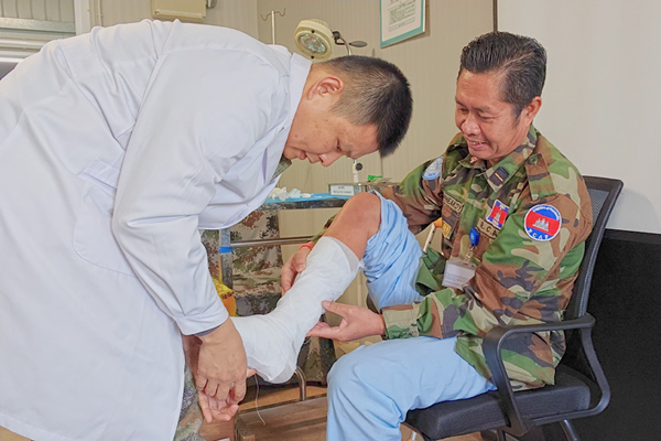 中國第22批赴黎維和醫(yī)療分隊軍醫(yī)為患者打石膏固定患肢。李清竹攝