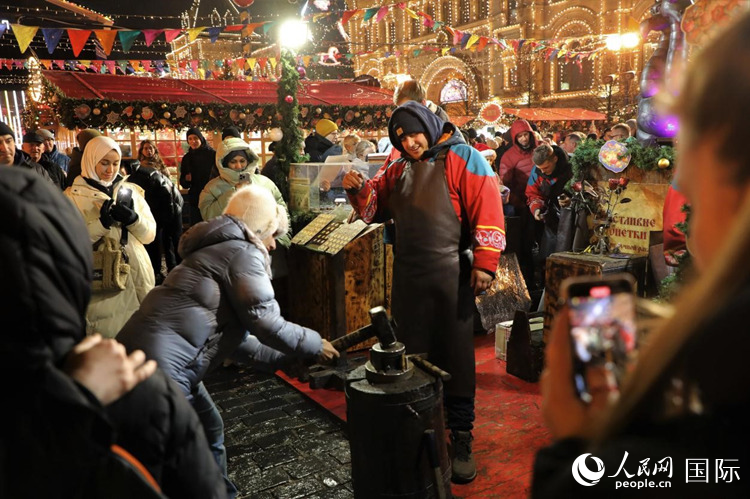 游客在新年集市上體驗制作紀念幣。人民網(wǎng)記者 隋鑫攝
