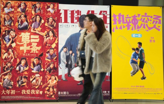 這是2月17日，在沈陽一家影院，觀眾從海報(bào)前經(jīng)過。新華社記者李鋼攝