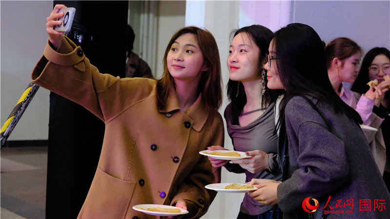 中國觀眾在現(xiàn)場品嘗“謝肉節(jié)”節(jié)日美食——煎薄餅。人民網(wǎng) 褚夢琦攝