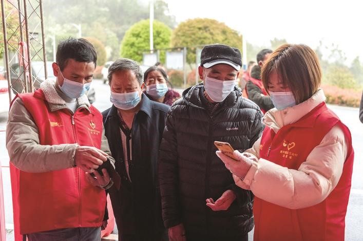 長沙縣黨員志愿者正在幫助參與核酸檢測的群眾掃描“場所碼”。劉思源 攝