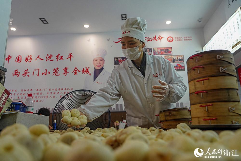 3月31日，在浙江省嵊州市甘霖鎮(zhèn)，嵊州小吃從業(yè)者沈紅平把蒸熟的小籠包晾涼，打包冷藏售賣。人民網(wǎng) 章勇濤攝