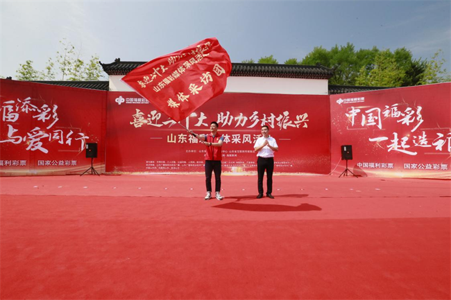 為媒體采風(fēng)團(tuán)授旗。 山東省福彩供圖