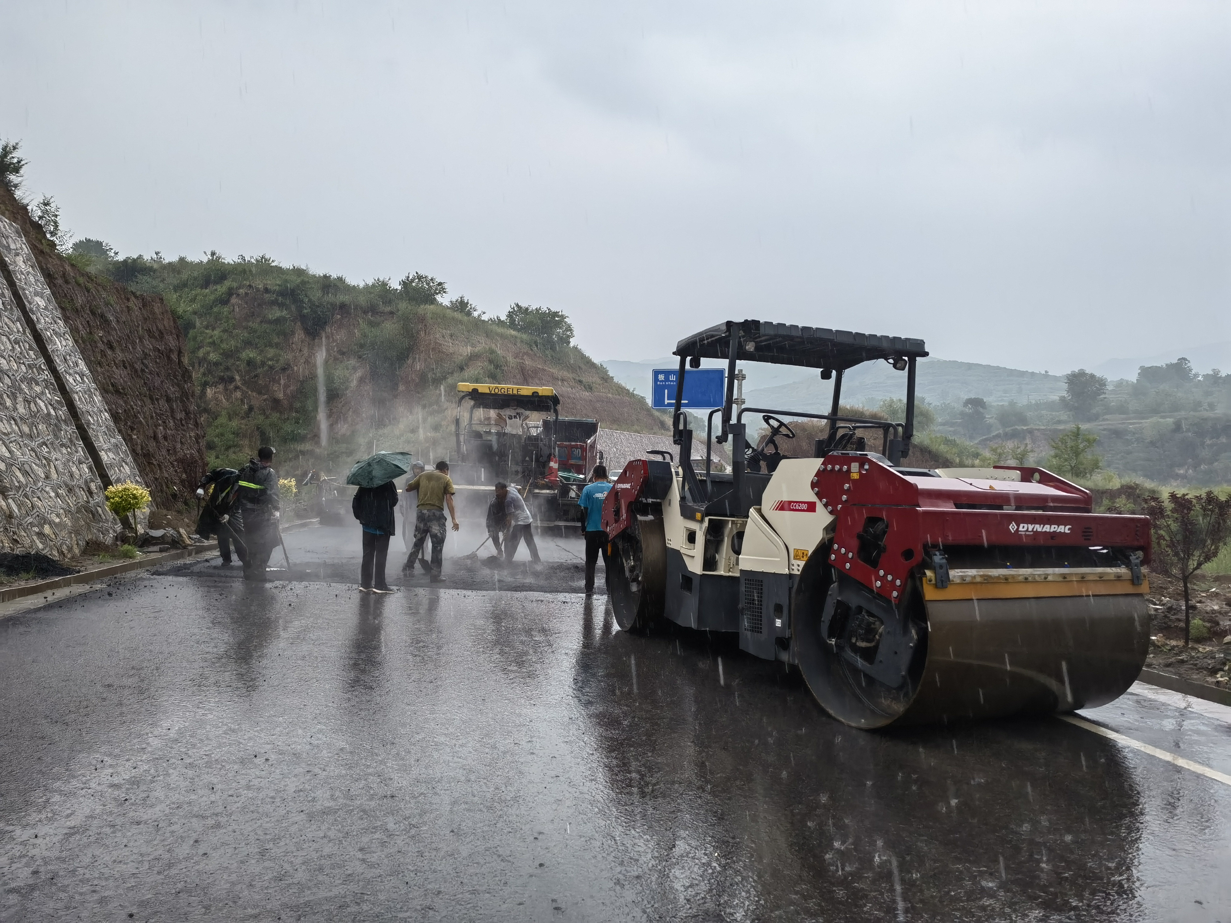 路橋工人在大雨中搶修道路。李華英 攝