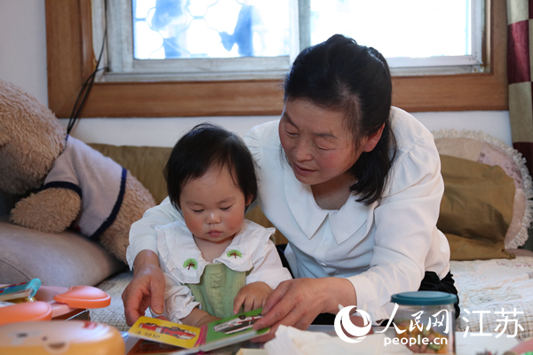 王繼蓮帶孫女看童書(shū)。人民網(wǎng) 冷金明攝