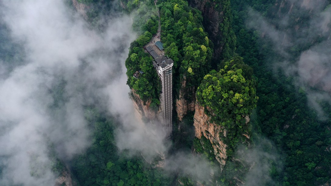 位于張家界武陵源景區(qū)的百龍?zhí)焯蓁偳对谠旗F繚繞的峰林間，雄偉壯觀。吳勇兵攝