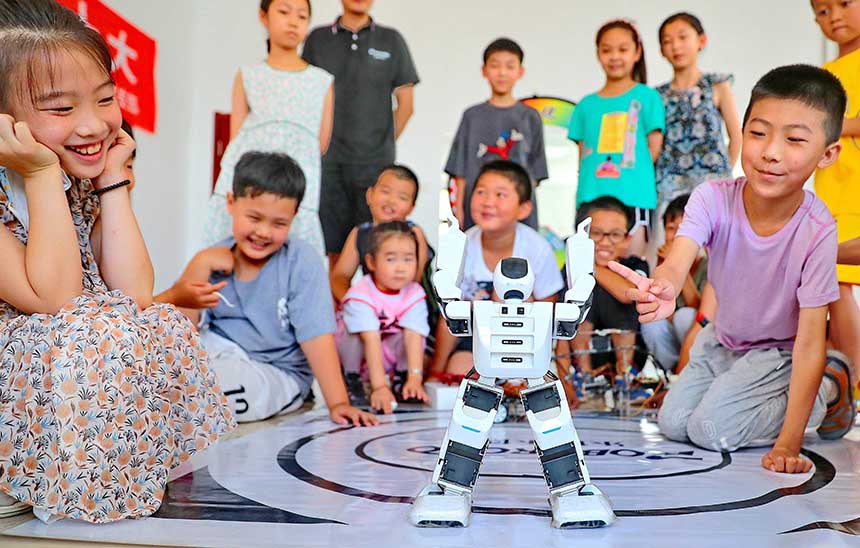 2022年7月19日，河北省秦皇島市海港區(qū)白塔嶺街道秦皇半島第二社區(qū)內(nèi)，小朋友正在觀看“機(jī)器人跳舞”。 曹建雄攝