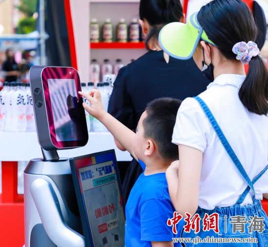 圖為一名小朋友正在和機(jī)器人“志愿者”進(jìn)行互動(dòng)。 沐聞 攝
