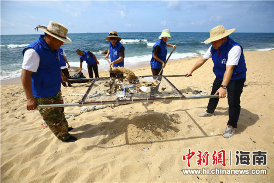 環(huán)保志愿者用篩網(wǎng)“淘”出海灘上的垃圾。