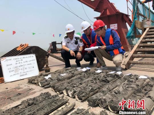 圖為勘察設(shè)計(jì)人員與海事局工作人員查看巖芯情況?！∥赫?攝