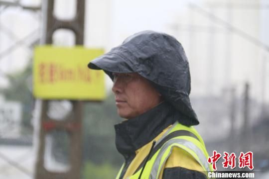 蘭州西工務(wù)段蘭州線路車間防護(hù)員雨中巡查?！⊥豕廨x 攝
