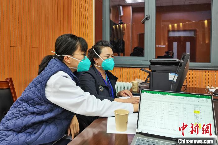 8月9日，楊蘇喬(左)在拉薩方艙醫(yī)院指揮部讀取艙內(nèi)患者胸部CT?！∈茉L者供圖
