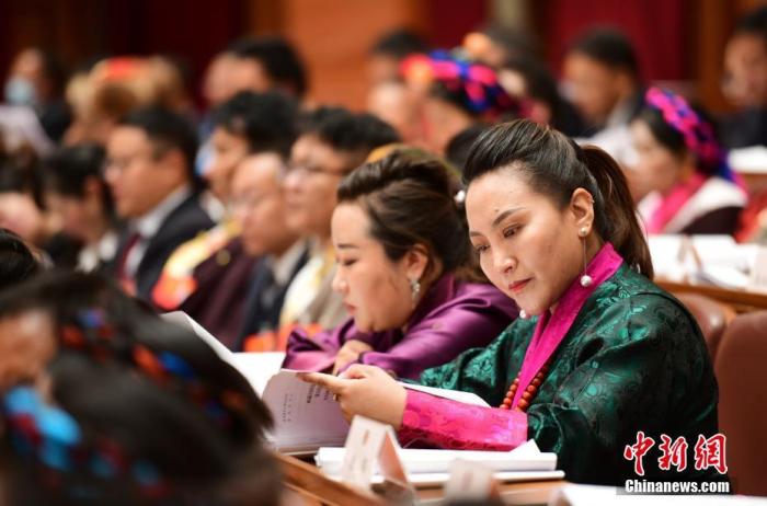 1月5日，次旦卓嘎(右一)在拉薩參加西藏自治區(qū)第十一屆人民代表大會第五次會議第二次全體會議。西藏自治區(qū)人大代表次旦卓嘎來自日喀則市定日縣，定日縣被稱為“洛諧故鄉(xiāng)”，作為西藏民間歌舞，洛諧已被列入中國國家非物質文化遺產(chǎn)項目名錄，這是集歌、舞、樂、彈唱于一體的綜合藝術形式。參加完西藏2022年新年音樂會的次旦卓嘎告訴記者，每年參加的基層演出可達80場，“我希望用最純粹的方式，把最好的聲音帶到西藏乃至中國的各個角落?！?<a target='_blank' href='/'><p  align=