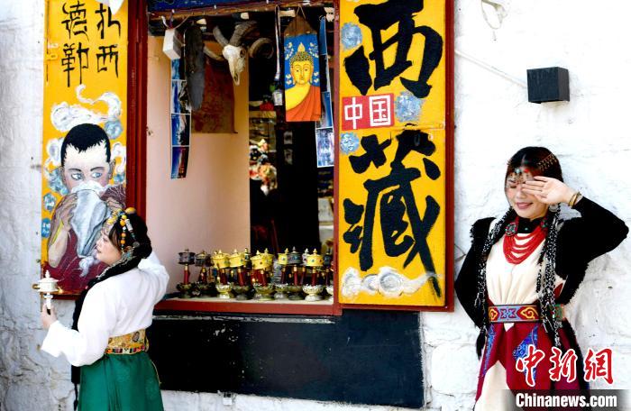 4月17日，游客身著藏式元素服裝在拉薩八廓街拍照留念。　李林 攝