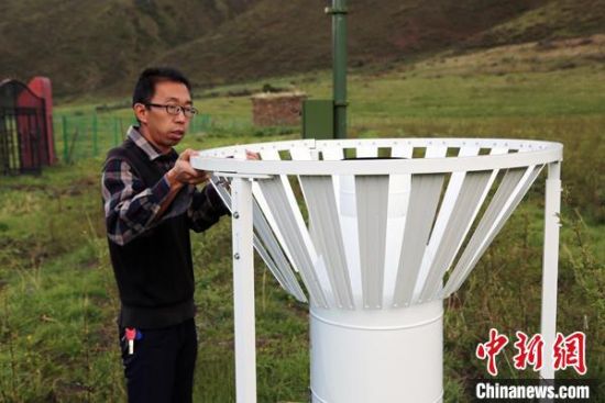 圖為班瑪縣氣象局工作人員在維護藏雪茶基地氣候站。青海省氣象局供圖