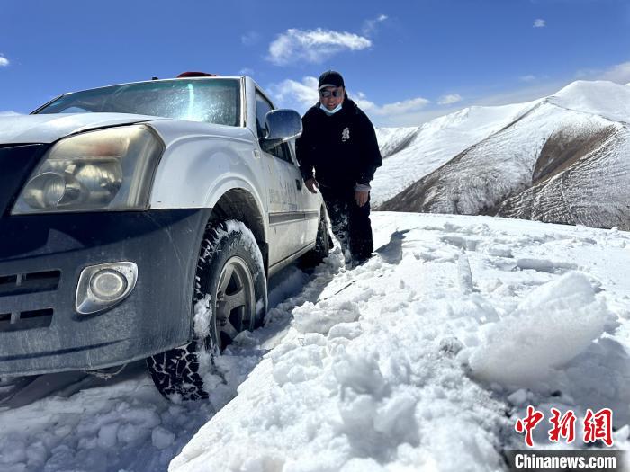 圖為生態(tài)管護人員準備在雪地推車?！《“瓦_杰 攝