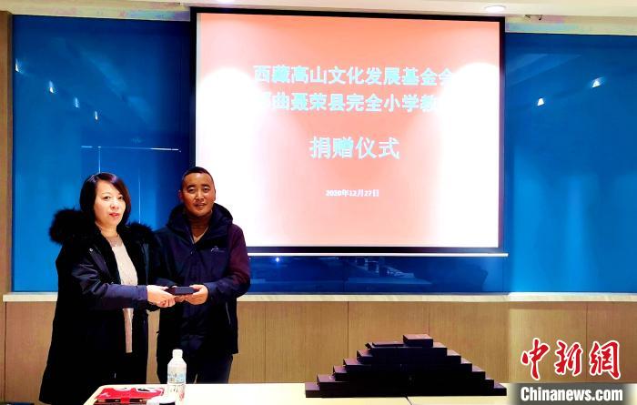 圖為西藏高山文化發(fā)展基金會理事長溫麗向聶榮縣完全小學(xué)負(fù)責(zé)人捐助儀器。　于賓 攝